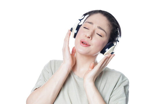 young woman singing along while listening to music through headphones with eyes closed