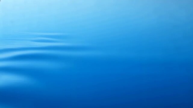 Gentle blue water surface with subtle ripples and smooth wave patterns