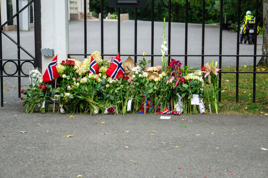 Norway national mourning displaying flowers and flags at Royal Palace gate