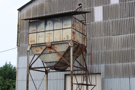 Ancienne installation de stockage de c&eacute;r&eacute;ales au sein d&rsquo;une coop&eacute;rative agricole, avec silo m&eacute;tallique et tr&eacute;mie de stockage ext&eacute;rieure