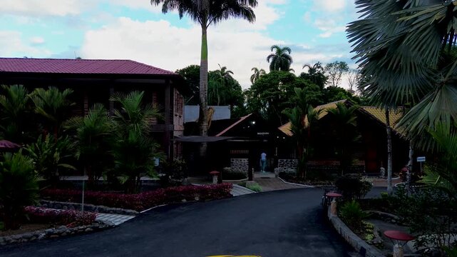 Tropical Eco Lodge Entrance in Ecuador Rainforest with Palm Trees, Yellow Taxi, Garden Road and Jungle Resort Travel Destination Scene