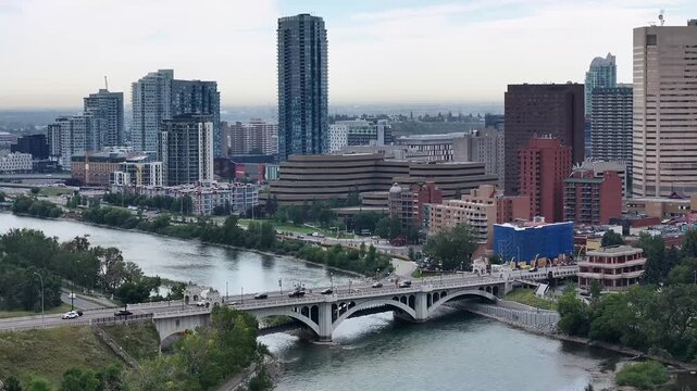 hovering in front of historic Centre St Bridge crossing the Bow River, in Downtown Calgary, Alberta, Canada, with traffic passing over the bridge in both directions. Cityscape of Downtown 