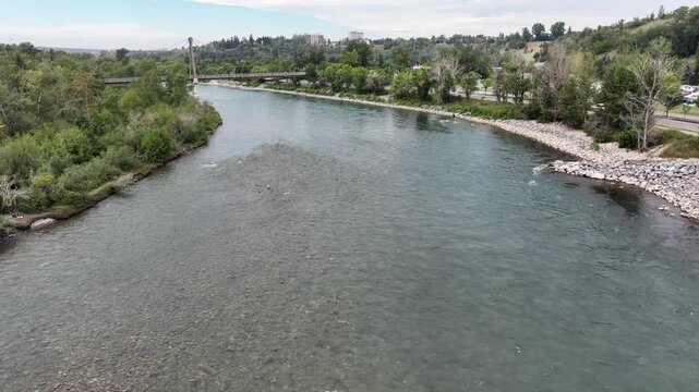 low level flying above Bow River next to Prince&rsquo;s Island Park, towards to Bow River Pathway Bridge at Memorial Dr, located next to Downtown Calgary ( Alberta, Canada) - 4k aerial video footage 