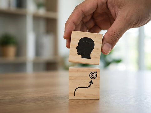 Hand stacking wooden blocks with head icon