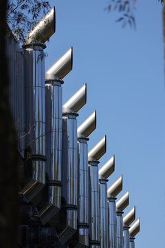View of the metallic exhaust pipes of a data center against a clear blue sky in Sydney, New South Wales, Australia.