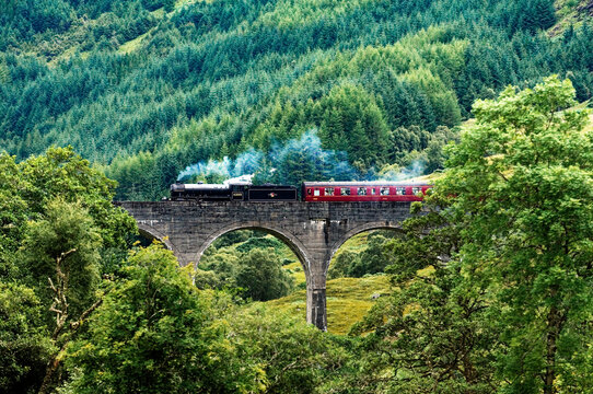 Steam engine Lord of the Isles pulls passenger train across Glenfinnan Viaduct to Mallaig from Fort William. Highland, Scotland
