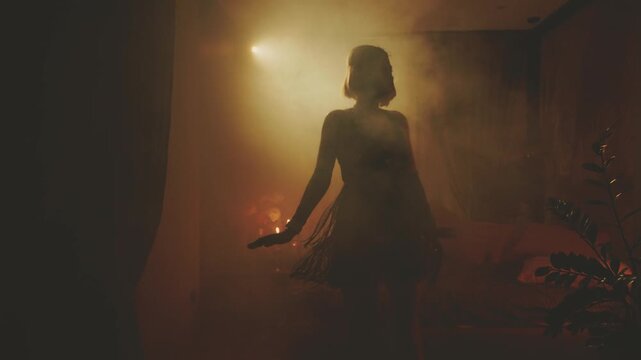 Old film style black dark female silhouette dancing. fashion model sexy vintage dress fringe waving. retro young happy woman dancer at night club party have fun. room full smoke back light rays flare.