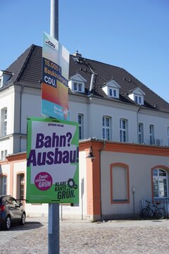 Wahlplakate der CDU (mit dem Slogan "15.000 &euro; Baukindergeld") und von B&uuml;ndnis 90/Die Gr&uuml;nen ("Bahn? Ausbau!") zur Landtagswahl in Mecklenburg-Vorpommern am Bahnhof in Neubrandenburg am 27.08.2026