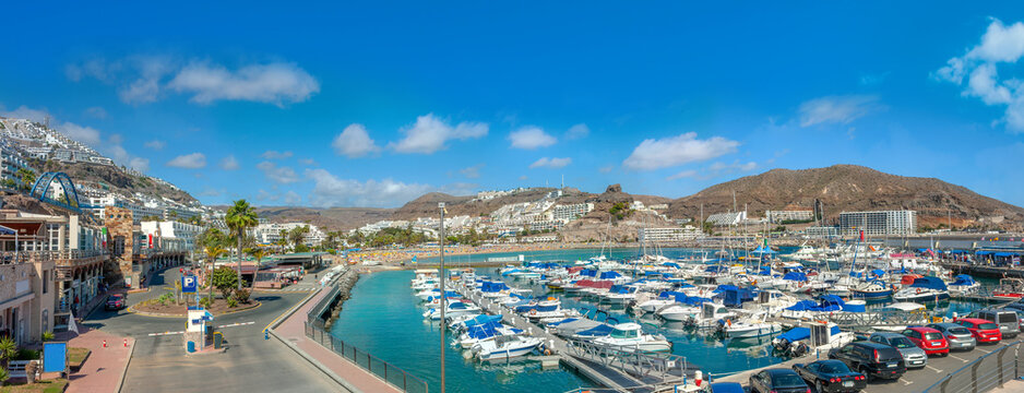 Panoramic view of wharf with yachts and coastline in Puerto Rico resort town. Gran Canaria, Spain