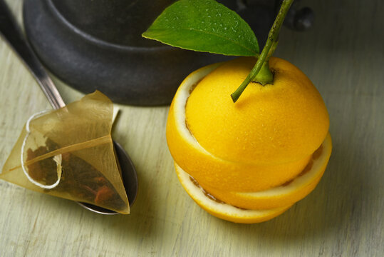 Lemon and Tea Bag Still Life. A sliced and stacked fresh ripe lemon in front of a tea pot with a spoon and tea bag. High angle shot.