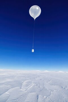 Radiosonde weather balloon rising above a snowfield
