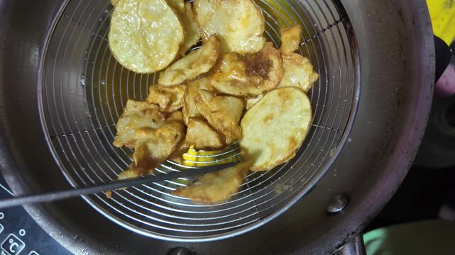 Golden Brown Potatoes Cooking in Oil , straining the fried oil  and taking out