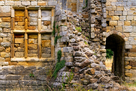 Detail of the historic Mulgrave Castle ruins near Whitby, showing weathered stone walls, an old staircase and arched passageway.