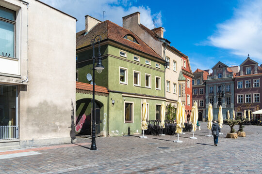 View of the historic Old Market Square with colorful buildings, cobblestone pavement, and closed umbrellas in Poznan, Greater Poland Voivod, Poland.