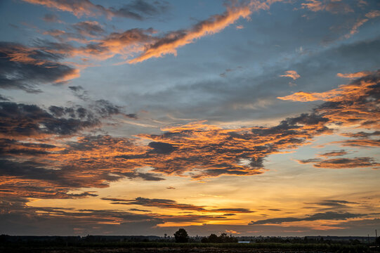 Vibrant Sunset Sky Background with Orange and Blue Dramatic Clouds.