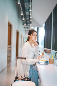 Beautiful young adult business asian woman using laptop work and travel using wireless digital technology at coffee cafe