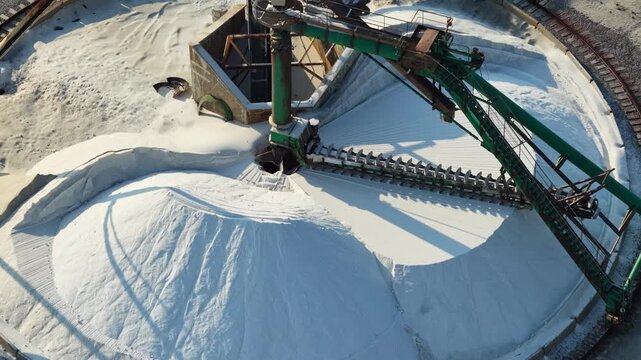 Automated conveyor system handling large quantities of industrial salt inside a processing facility for refining, treatment and further production