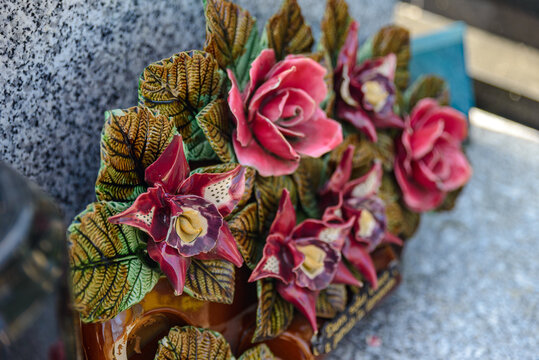 Ornement floral fun&eacute;raire en c&eacute;ramique &eacute;maill&eacute;e sur une tombe
