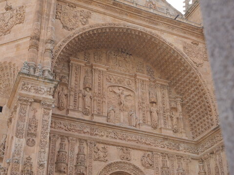 View of the ornate Plateresque facade of the Convento de San Esteban featuring intricate stone carvings and religious sculptures in Salamanca, Castile and Leon, Spain.