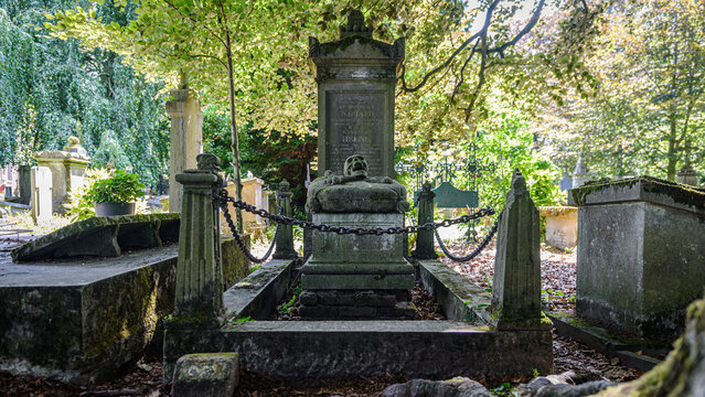 Monument fun&eacute;raire avec t&ecirc;te de mort en pierre et cha&icirc;nes de cl&ocirc;ture
