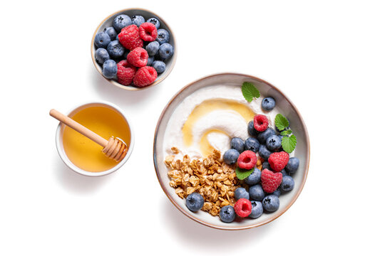 Granola bowl with greek yogurt, berries and honey for healthy breakfast.