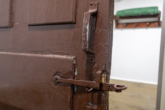 Weathered brown wooden door with rusty metal latch in domestic interior rustic style
