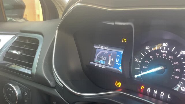 Dashboard display of a vehicle showing oil change notification, mileage, and warning lights in a modern car interior with detailed instrument panel and controls. High quality 4k footage