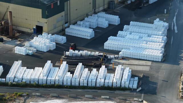 Aerial view of packaged white sea salt products stored outside an industrial salt processing and distribution facility near Aigues-Mortes in southern France