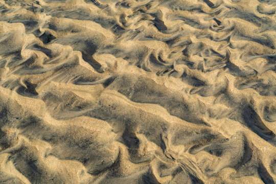 View of intricate patterns formed by wind and water on the sandy beach surface at Jandia, Canarias, Spain.