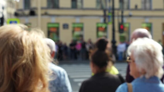 Blurred pedestrians waiting at traffic light city street