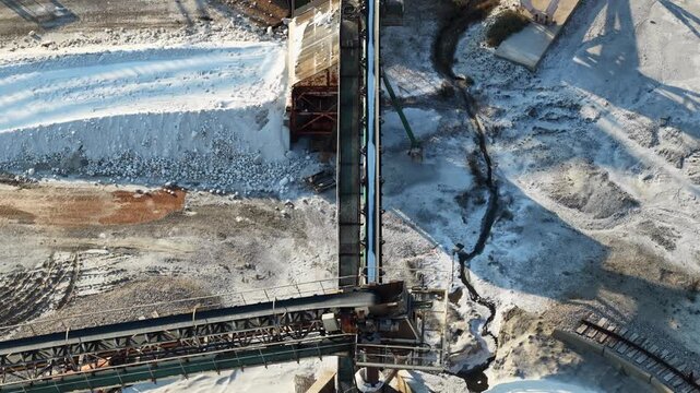 Automated conveyor system handling large quantities of industrial salt inside a processing facility for refining, treatment and further production