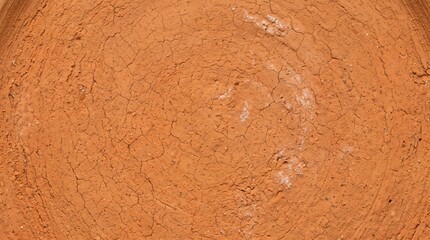 Fototapeta premium Close up of dry cracked orange clay earth surface showing intricate patterns of drought and heat