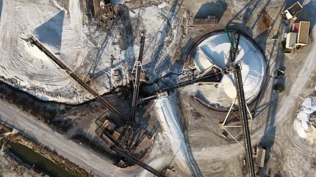 Automated conveyor system handling large quantities of industrial salt inside a processing facility for refining, treatment and further production