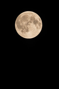 Beautiful vertical view of a full moon with copy space isolated on a black night sky background