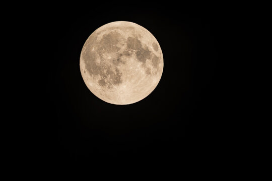 Beautiful close up view of a full moon isolated on a black night sky background