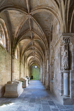 View of the historic cloister of the Cathedral of Evora with stone vaulted ceilings, ornate columns, and ancient sarcophagi in Evora, Distrito de Evora, Portugal.