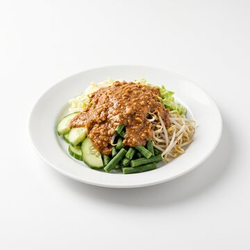 Delicious Indonesian Karedok Salad with Fresh Vegetables and Rich Peanut Sauce on White Plate