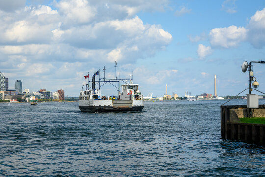 Passenger ferry arriving at a dock on the Toronto Islands with the city skyline in the background on a sunny summer day