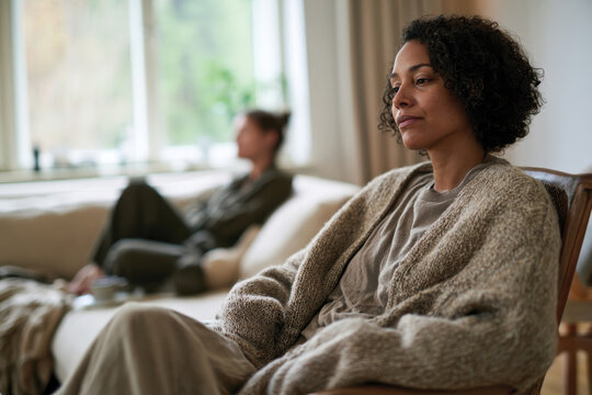 A woman portrayed in a peaceful state of reflection within a cozy living space, representing moments of contemplation and personal connection in everyday life.