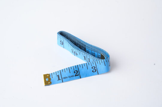 A blue flexible measuring tape laid out on a white surface, showing measurements in inches.