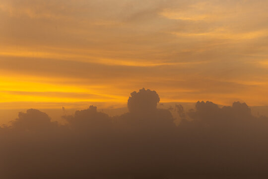 View of silhouettes of trees against a vibrant orange and yellow sunset sky in Jahanian, Punjab, Pakistan.