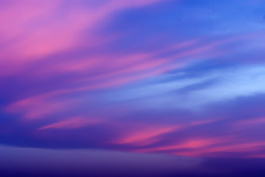 View of vibrant sunset sky with streaks of pink and deep blue clouds in Jahanian, Punjab, Pakistan.
