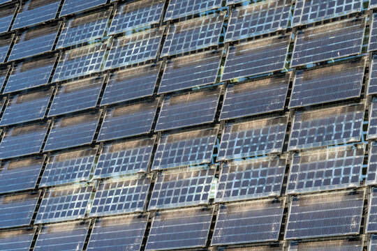 View of vertical solar panels arranged in a grid pattern covering an entire building facade in The Netherlands.