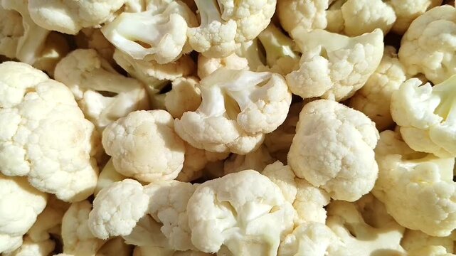 Close view of fresh cauliflower and broccoli florets in a food video. Raw vegetables, healthy ingredients, fresh produce, cooking content.