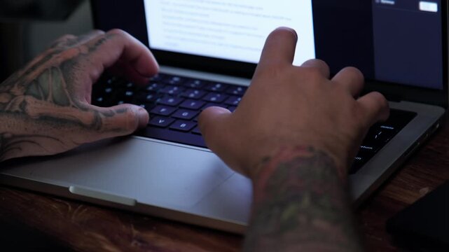 Typing on a laptop in a cozy indoor setting while working on a project in the afternoon
