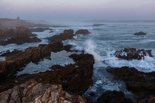 beautiful rocky coastline of Kammabaai Beach, Hermanus, South Africa at sunset and dusk