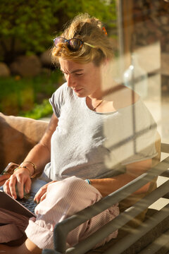 young woman using laptop computer on outdoor couch