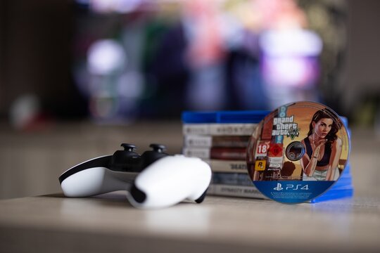 BRECHT, BELGIUM &ndash; August 28, 2026: Closeup portrait of a stack of PS5 playstation games, a controller, a physical game disc and a blurred home screen in the background.