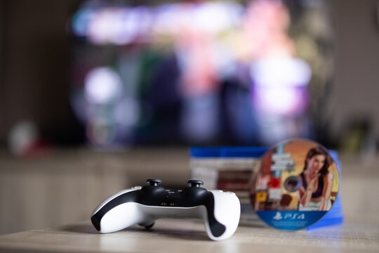 BRECHT, BELGIUM &ndash; August 28, 2026: Closeup portrait of a closed PS5 game case with a stack of PlayStation 5 games and a disc in the background, highlighting physical gaming media.
