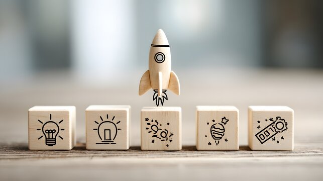 Small wooden rocket taking off above row of wooden blocks stamped with business innovation icons.
